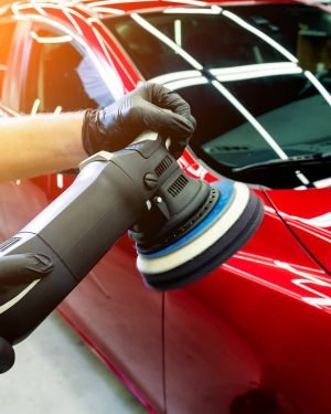 Car service worker polishes a car with orbital polisher. Car service worker polishes a car with orbital polisher.